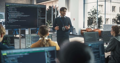 man stood in front of audience talking 