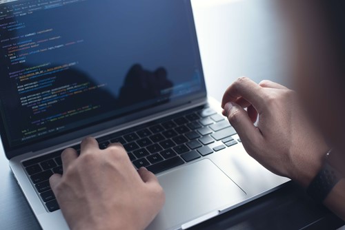 hands typing on a laptop